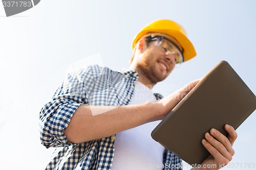 Image of close up of builder in hardhat with tablet pc