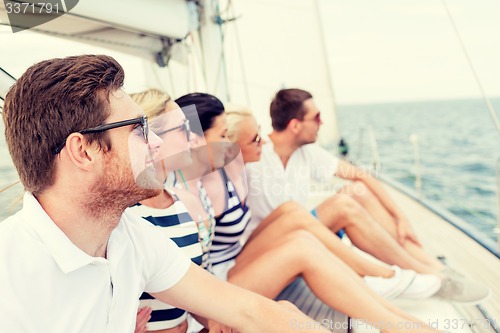 Image of smiling friends sitting on yacht deck