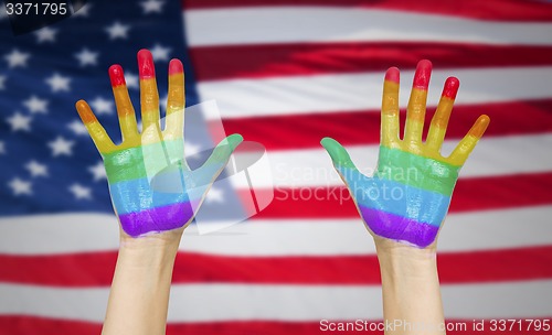 Image of hands painted in rainbow colours and american flag