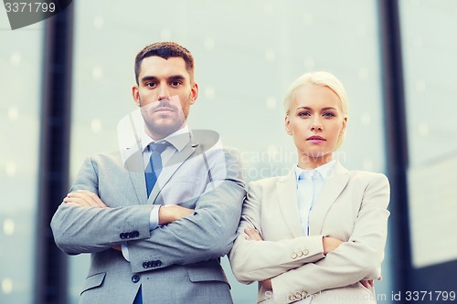 Image of serious businessmen standing over office building