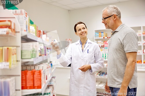 Image of pharmacist showing drug to senior man at pharmacy