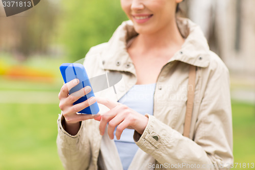 Image of close up of woman calling on smartphone in park