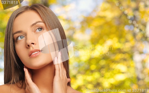 Image of beautiful young woman touching her neck