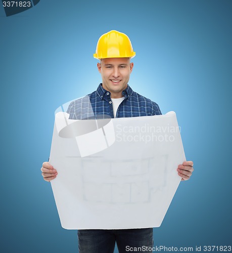 Image of smiling male builder in helmet with blueprint