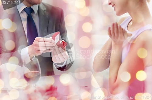 Image of excited young woman and boyfriend giving her ring