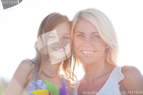 Image of happy mother and child girl with pinwheel toy