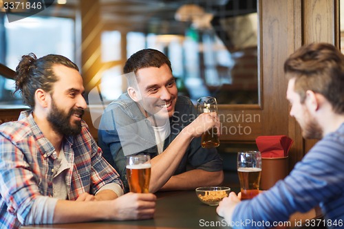 Image of happy male friends drinking beer at bar or pub