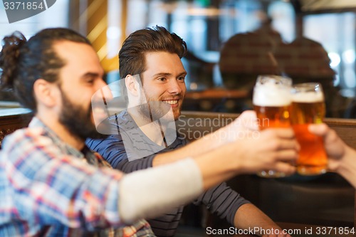 Image of happy male friends drinking beer at bar or pub