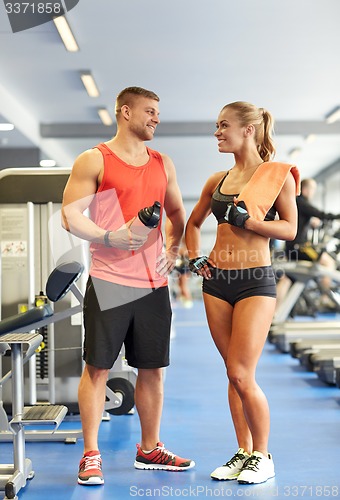 Image of smiling man and woman talking in gym