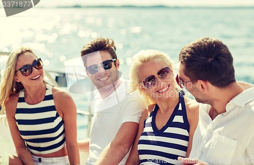 Image of smiling friends sitting on yacht deck