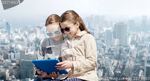 Image of happy girls with tablet pc computer over city