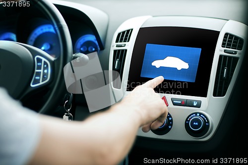 Image of male hand pointing finger to car icon on panel