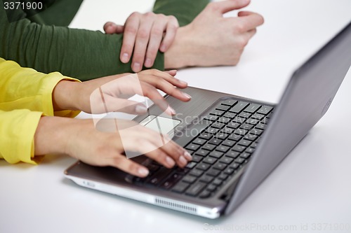 Image of close up of female hands with laptop typing