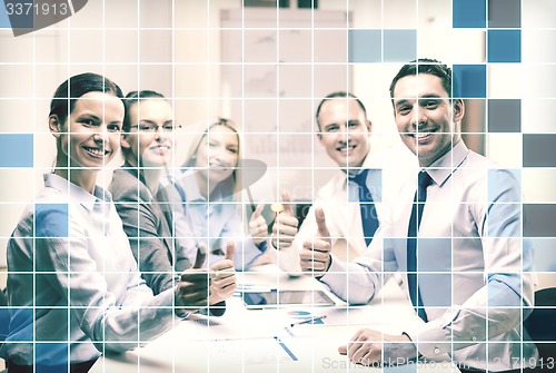 Image of business team showing thumbs up in office