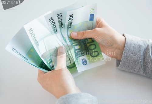 Image of close up of woman hands counting euro money