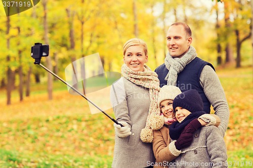 Image of happy family with smartphone and monopod in park