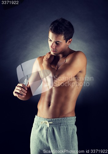 Image of young male bodybuilder applying pain relief gel