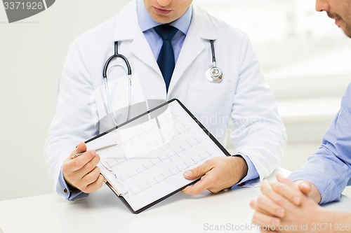 Image of close up of male doctor and patient with clipboard