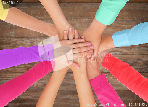 Image of close up of women hands on top in rainbow clothes