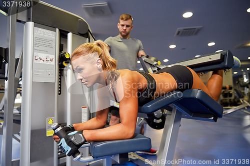 Image of man and woman flexing muscles on gym machine