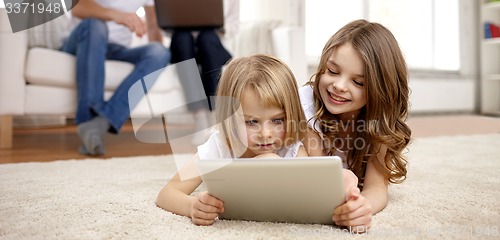 Image of happy little girls with tablet pc computer at home