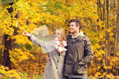 Image of smiling couple hugging in autumn park