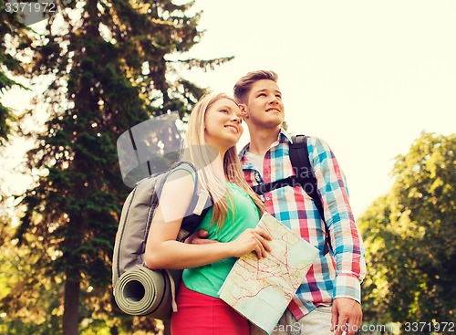 Image of smiling couple with map and backpack in nature