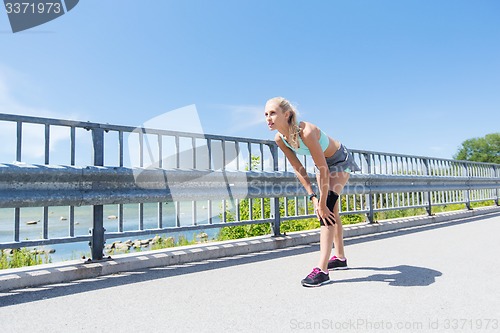 Image of young woman with injured knee or leg outdoors