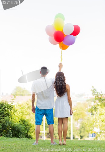 Image of happy couple with air balloons in city