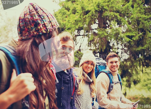 Image of group of friends with backpacks and tablet pc