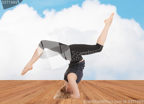 Image of happy young woman doing yoga exercise