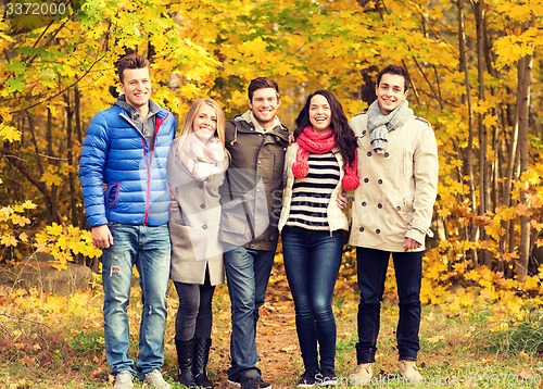 Image of group of smiling men and women in autumn park