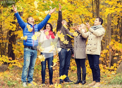 Image of group of smiling men and women in autumn park