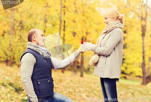 Image of smiling couple with engagement ring in gift box