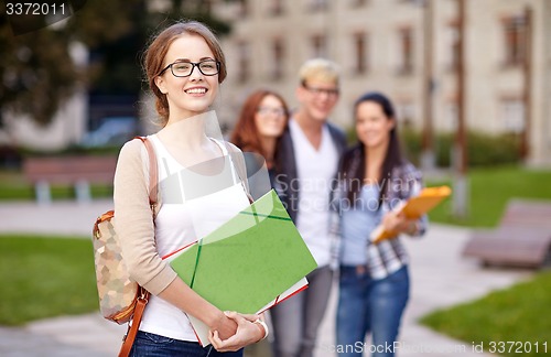 Image of happy teenage students with school folders