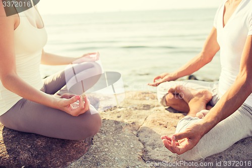 Image of close up of couple making yoga exercises outdoors