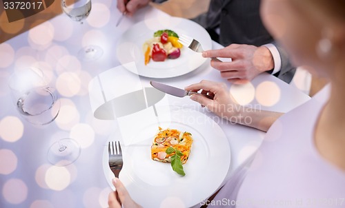 Image of close up of couple eating appetizers at restaurant