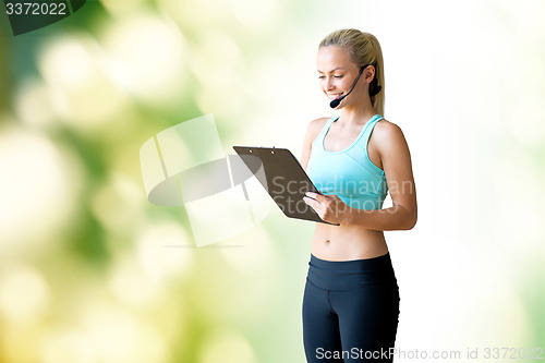 Image of happy woman trainer with microphone and clipboard