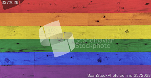 Image of gay pride rainbow flag pattern on wooden surface