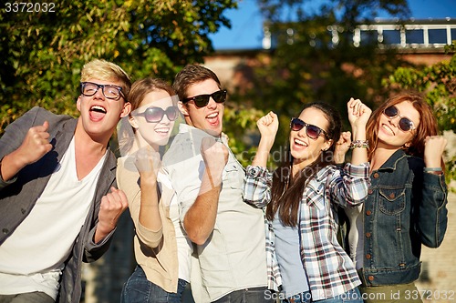 Image of group of happy friends showing triumph gesture