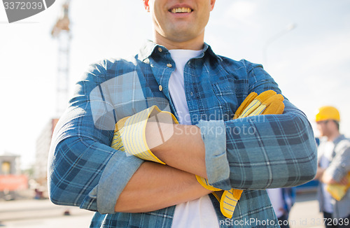 Image of close up of smiling builder hands in gloves