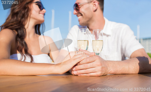 Image of happy just married couple with champagne at cafe