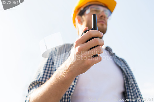 Image of close up of builder in hardhat with walkie talkie