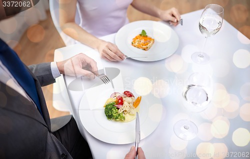 Image of close up of couple eating appetizers at restaurant