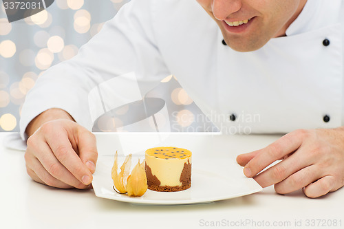 Image of close up of happy male chef cook with dessert