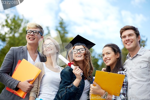 Image of group of smiling students with diploma and folders