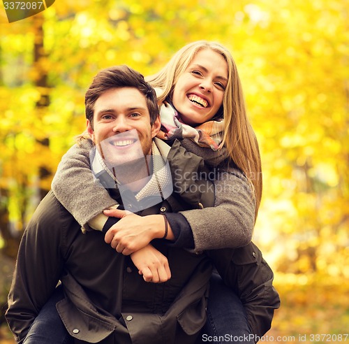 Image of smiling couple having fun in autumn park