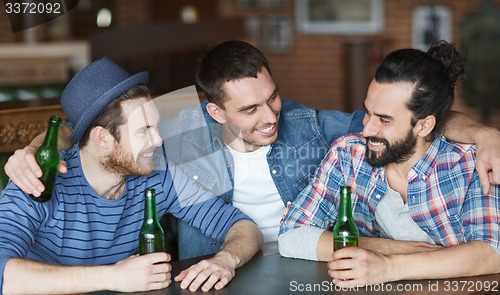 Image of happy male friends drinking beer at bar or pub