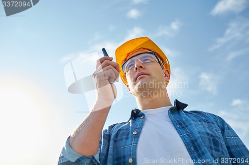 Image of builder in hardhat with walkie talkie