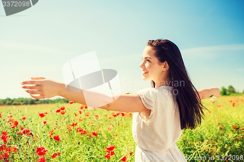 Image of smiling young woman on poppy field